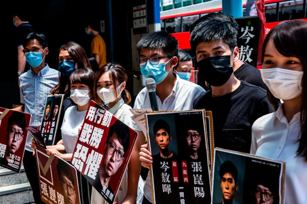 (L-R) Pro-democracy activists Eddie Chu, Gwyneth Ho, Leung Hoi-ching, Tiffany Yuen, Joshua Wong, Lester Shum, and Agnes Chow campaign during primary elections in Hong Kong on July 12, 2020. (Issac Lawrence/AFP via Getty Images)