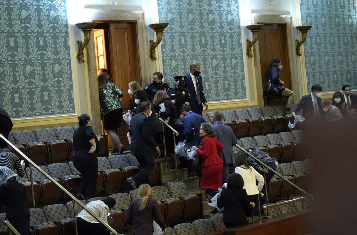 Members of Congress evacuate the House Chamber as a group of protesters attempt to enter during a joint session of Congress in Washington on Jan. 6, 2021. (Drew Angerer/Getty Images)
