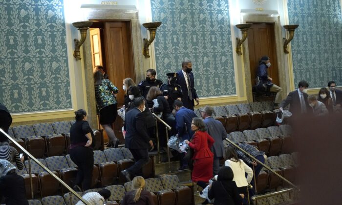 Members of Congress evacuate the House Chamber as protesters attempt to enter during a joint session of Congress in Washington on Jan. 6, 2021. (Drew Angerer/Getty Images)