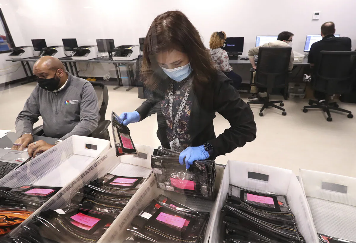 Election workers tabulate ballots at the Beauty P. Baldwin Voter Registrations and Elections Building in Lawrenceville, Ga., on Jan. 5, 2021. (Curtis Compton/Atlanta Journal-Constitution via AP)
