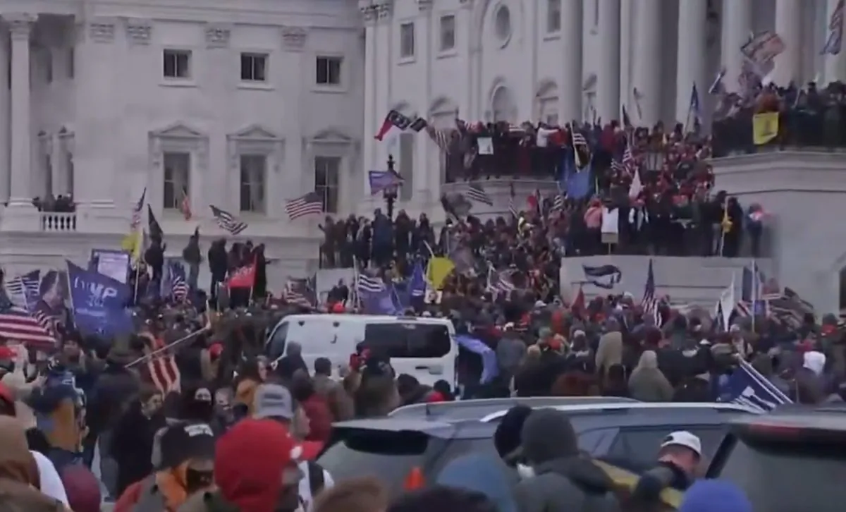 Numbers of protesters holding signs for President Donald Trump, American flags, Gadsden flags, outside the building. (NTD Live)