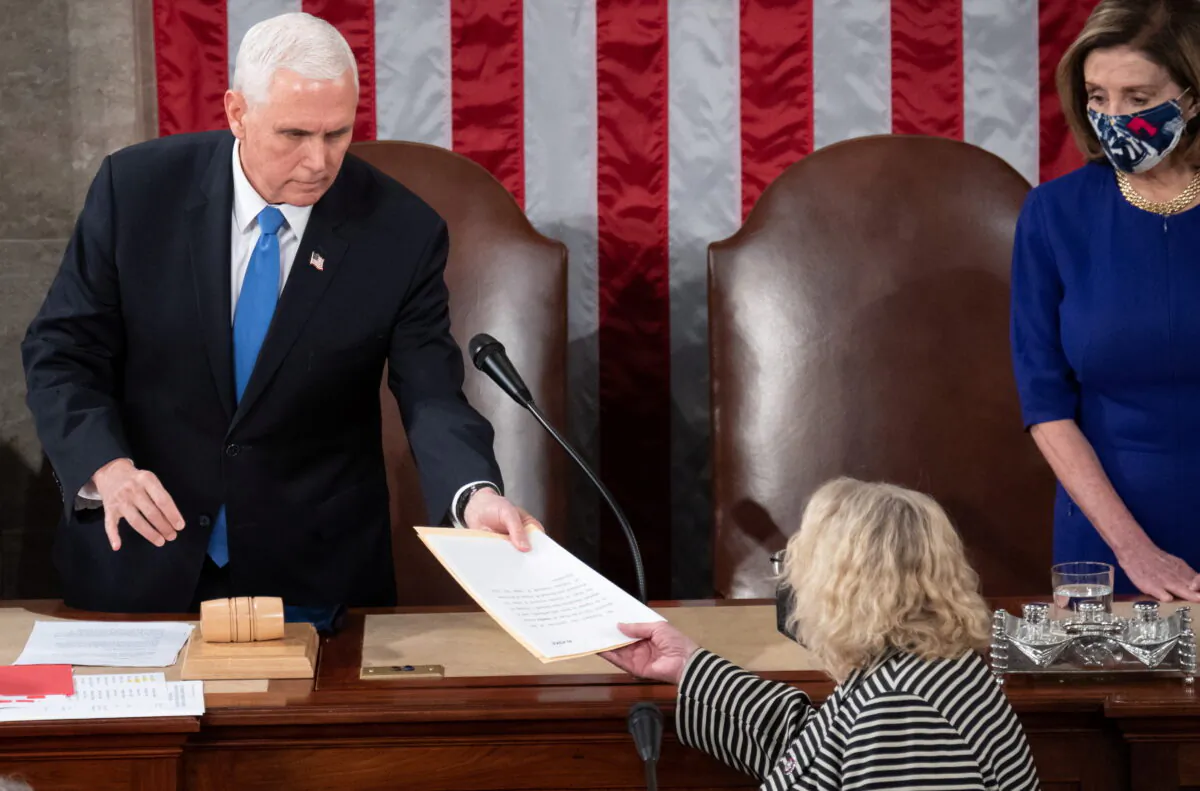 Vice President Mike Pence hands the electoral certificate from the state of Arizona to Rep. Zoe Lofgren (D-Calif.) as he presides over a joint session of Congress to certify the 2020 election results on Capitol Hill in Washington on Jan.6, 2021. (Saul Loeb/Pool via Reuters)