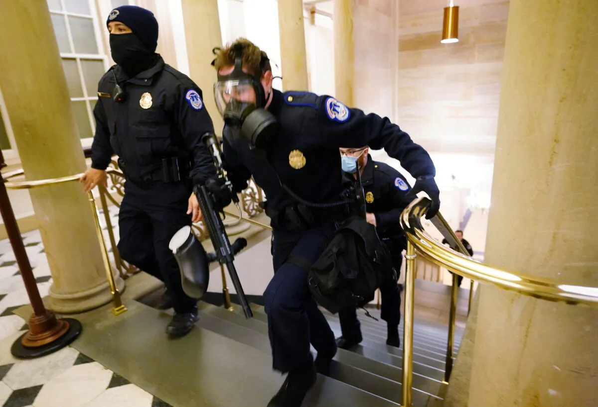 U.S. Capitol police officers take positions as rioters enter the Capitol building during a joint session of Congress in Washington on Jan. 6, 2021. (Kevin Dietsch/Pool via Reuters)