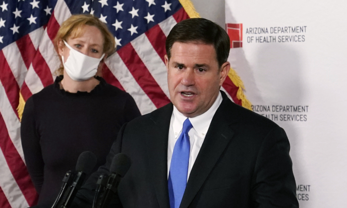 Arizona Gov. Doug Ducey answers a question about the arrival of a COVID-19 vaccine in Arizona, while Arizona Department of Health Services Director Dr. Cara Christ listens, in Phoenix, Ariz., on Dec. 2, 2020. (Ross D. Franklin, Pool/AP Photo)