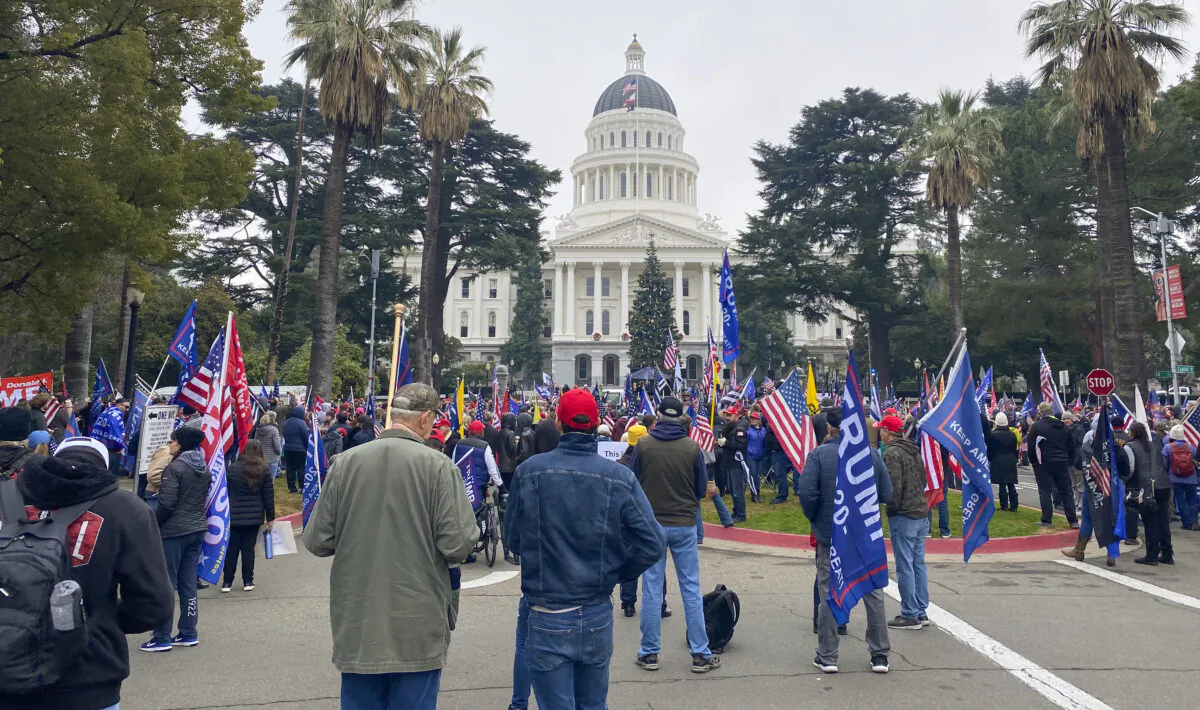 Rally attendees hold signs and flags at the California State Capitol in Sacramento, Calif., on Jan. 6, 2021. (Ilene Eng/The Epoch Times)