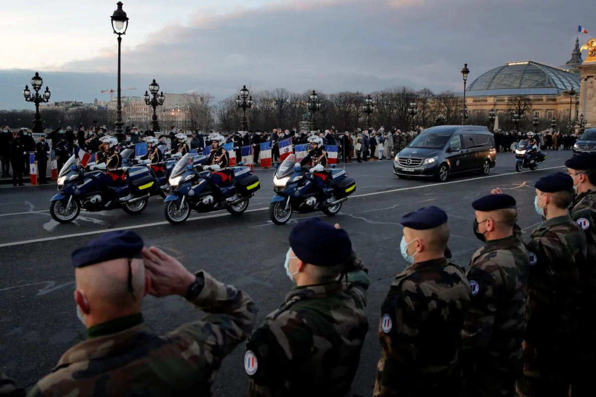 French soldiers stand in an honour guard as the hearse convoy of late French forces soldiers rides on the Alexandre III bridge in central Paris on Thursday, Jan. 7, 2021. (Christophe Ena/AP Photo)