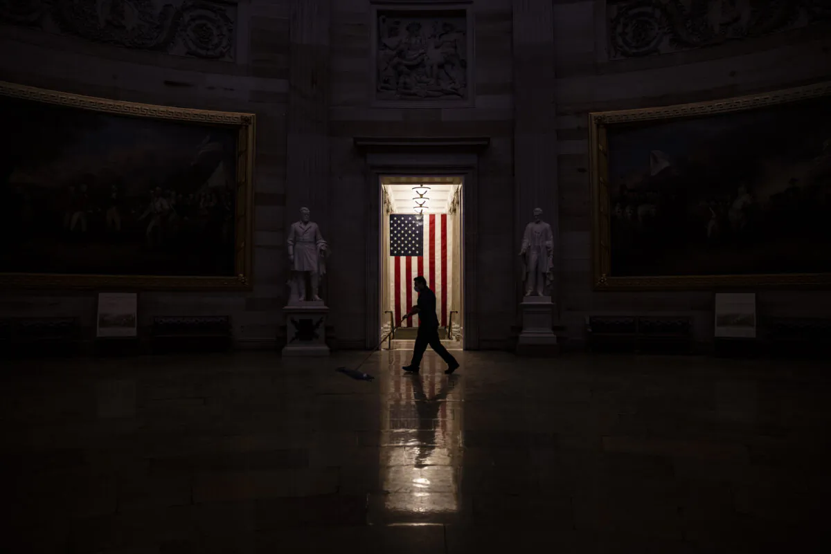 A worker sweeps up the dust and debris that was left behind by protesters in the Rotunda of the U.S. Capitol building on Jan. 7, 2021. (Samuel Corum/Getty Images)