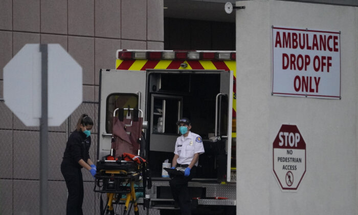 Emergency medical technicians sanitize an ambulance strecher after transporting a patient at Los Angeles County + USC Medical Center in Los Angeles on Jan. 5, 2021. (Damian Dovarganes/AP Photo)