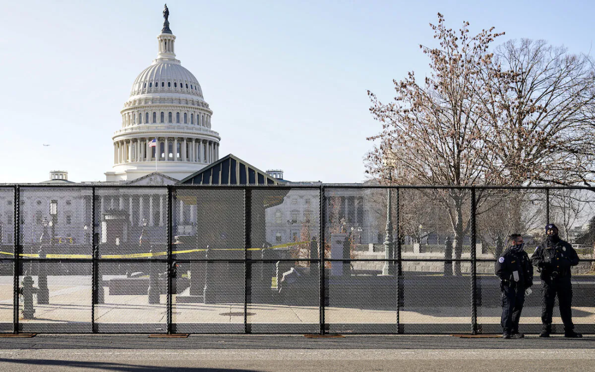 Capitol police officers stand outside of fencing that was installed around the exterior of the Capitol grounds, in Washington on Jan. 7, 2021. (AP Photo/John Minchillo)