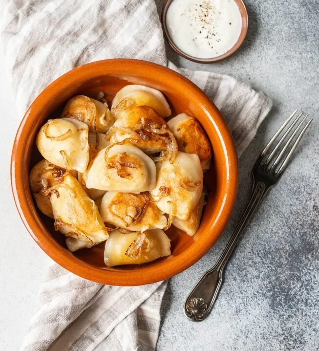 Pierogi can be simply boiled, or boiled first, then pan-fried in butter and served with sour cream or fried shallots or onions. (Sentelia/Shutterstock)