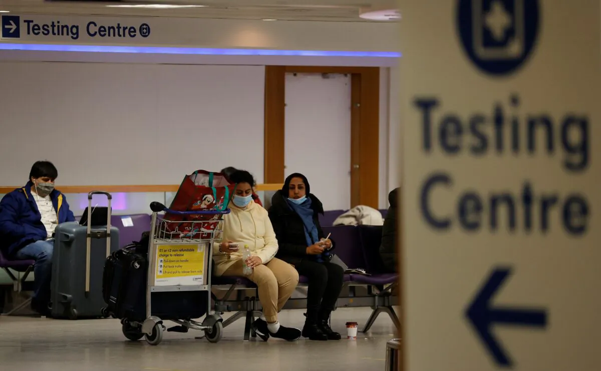 Passengers sit beneath a testing centre sign in the terminal building of Manchester Airport amid the outbreak of the coronavirus disease (COVID-19) in Manchester, Britain, Dec. 3, 2020. (Phil Noble/Reuters File Photo)