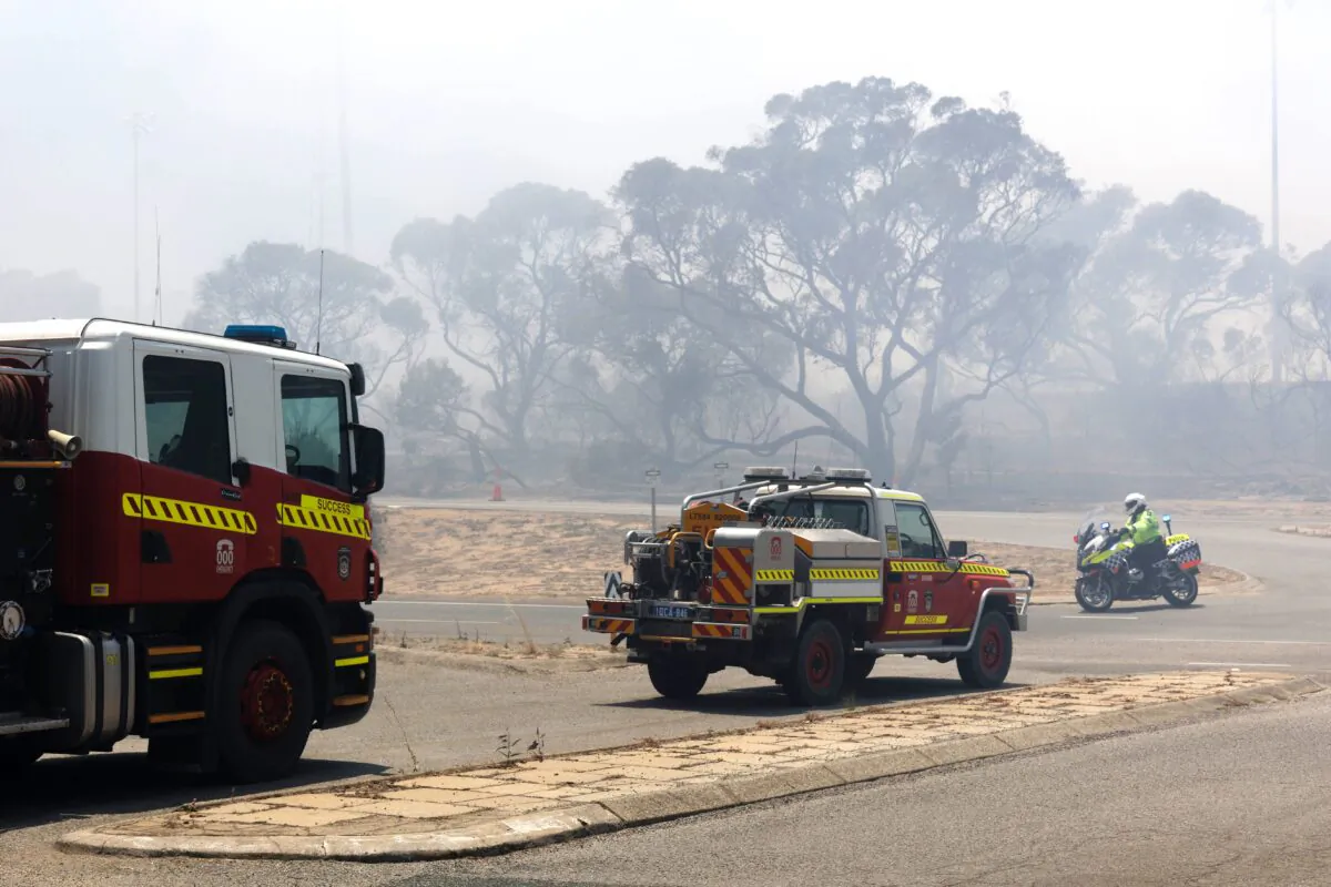 Emergency vehicles patrol the perimeter while battling a bush fire south of Perth on January 4, 2021. (Photo by TREVOR COLLENS/AFP via Getty Images)