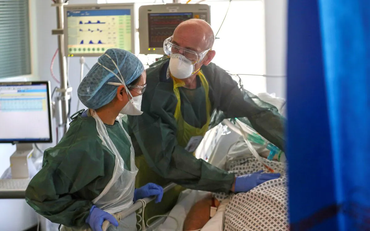 Medical staff wearing full PPE treat a CCP virus patient on an Intensive Care Unit (ICU) ward at Frimley Park Hospital in Frimley, England, on May 22, 2020. (Steve Parsons/Pool/AFP via Getty Images)