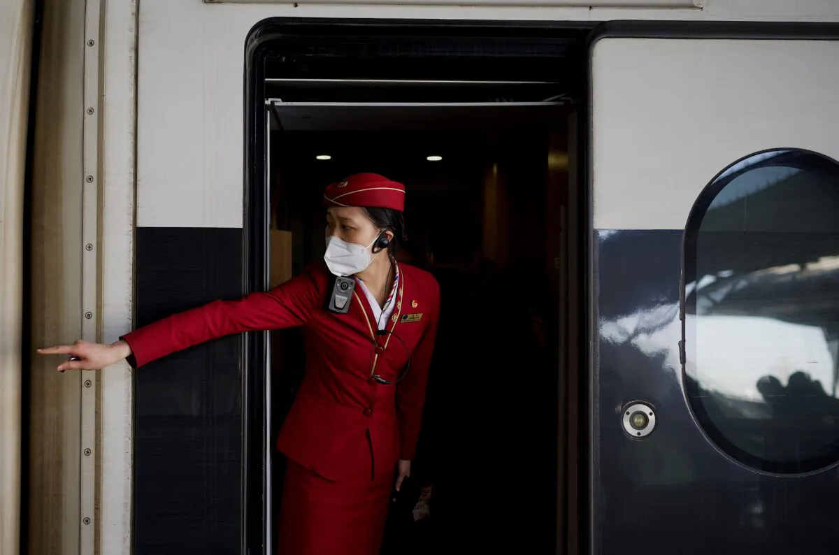 A train attendant signals to passengers to get in at Wuhan railway station on New Year's Eve in Wuhan in Chinas central Hubei province on Dec. 31, 2020. (Noel Celis/AFP via Getty Images)
