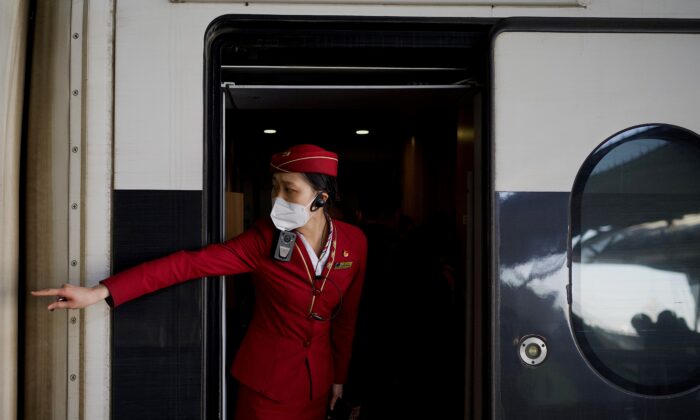 A train attendant signals to passengers to get in at Wuhan railway station on New Year's Eve in Wuhan in Chinas central Hubei province on Dec. 31, 2020. (Noel Celis/AFP via Getty Images)
