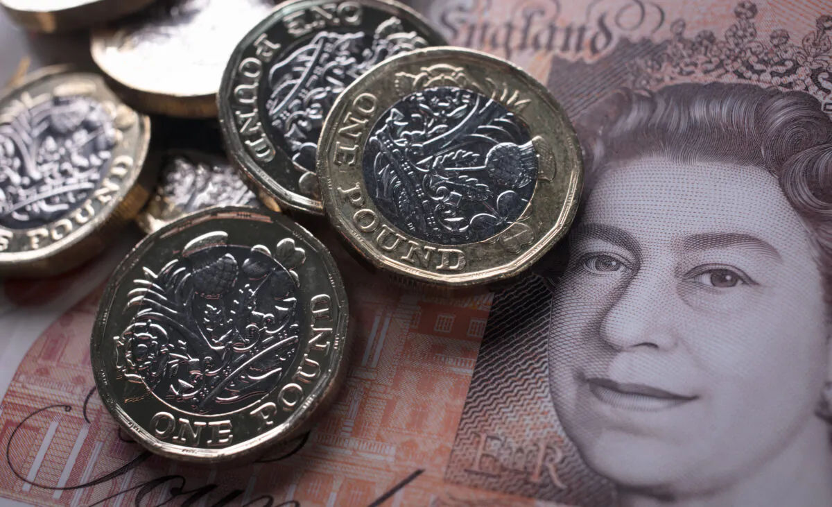 In this photo illustration, £1 coins are seen with a £10 note in Bath, England, on Oct. 13, 2017. (Matt Cardy/Getty Images)