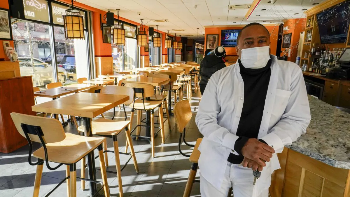 Andrew Walcott, owner of Fusion East Caribbean & Soul Food restaurant, poses for a photo at the restaurant in East New York neighborhood of New York City on Jan. 7, 2021. Walcott had to furlough four employees at his restaurant just before Christmas, after the state stopped allowing indoor dining. (Mary Altaffer/AP Photo)