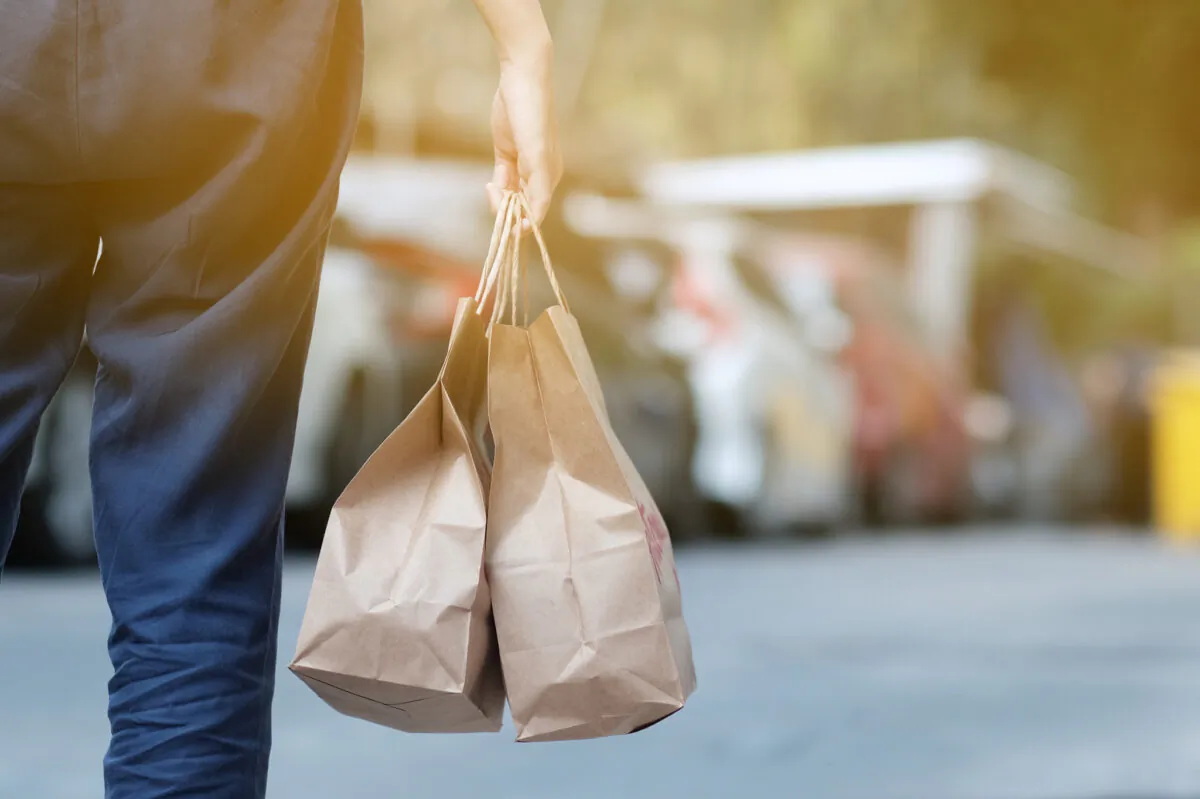 A woman carries a takeout order as restaurants remain closed for indoor dining due to pandemic restrictions. (Getty Images)