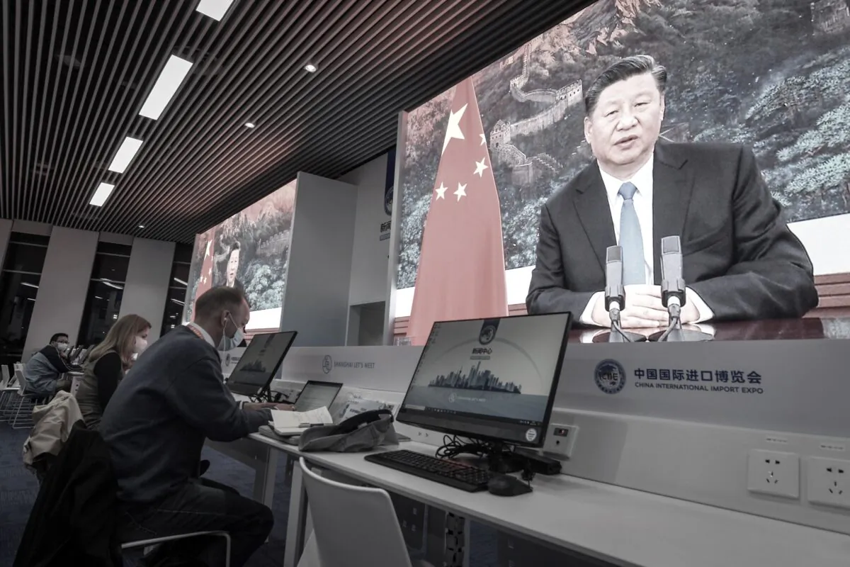 Journalists sit next to the screens showing Chinese leader Xi Jinping delivering a speech via video for the opening ceremony of the 3rd China International Import Expo at a media center in Shanghai on Nov. 4, 2020. (STR/AFP via Getty Images)