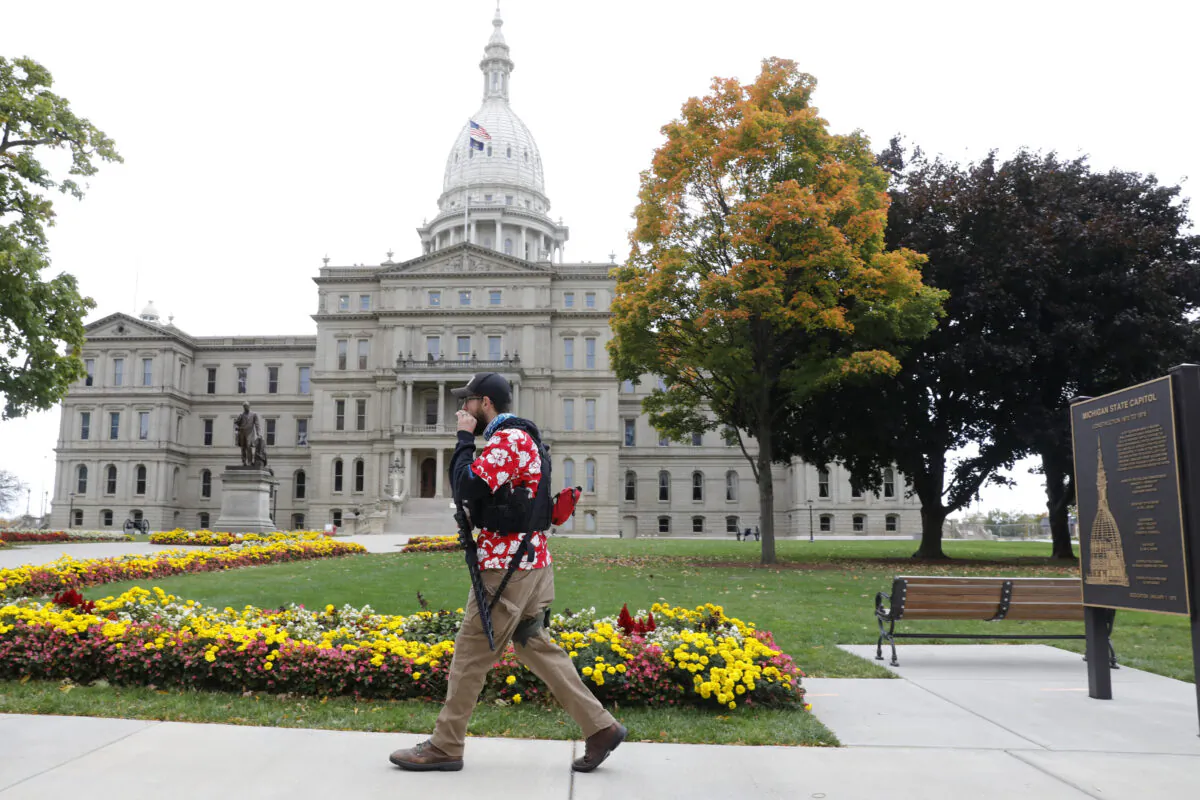 A man carries a firearm outside the Michigan State Capitol in Lansing, Mich., on Oct. 17, 2020. (Jeff Kowalsky/AFP/Getty Images)