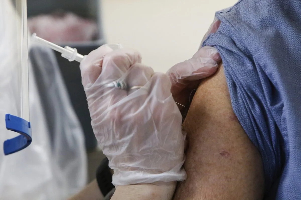 Walgreens pharmacist Mindy Keeton delivers a Moderna COVID-19 vaccine shot at the AHEPA apartments in Merrillville, Ind. on Jan. 11, 2020. (Kale Wilk/The Times via AP)