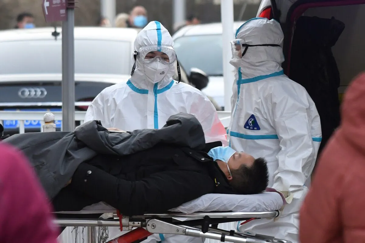 Medical workers deliver a patient to the fever clinic at a hospital in Beijing, on Jan. 13, 2021. (GREG BAKER/AFP via Getty Images)