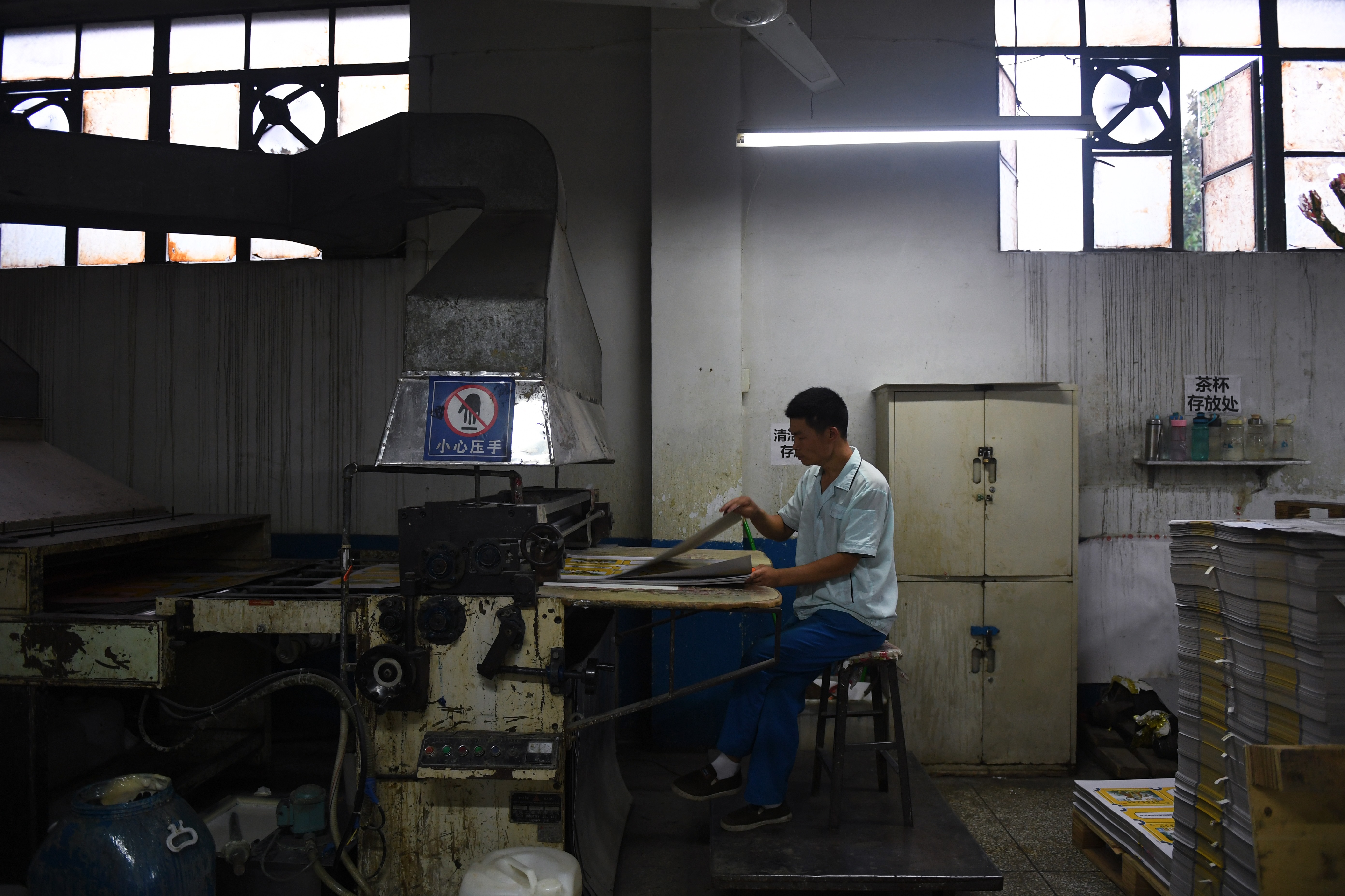 Egy munkás gépeket kezel egy nyomdában Nanjie faluban