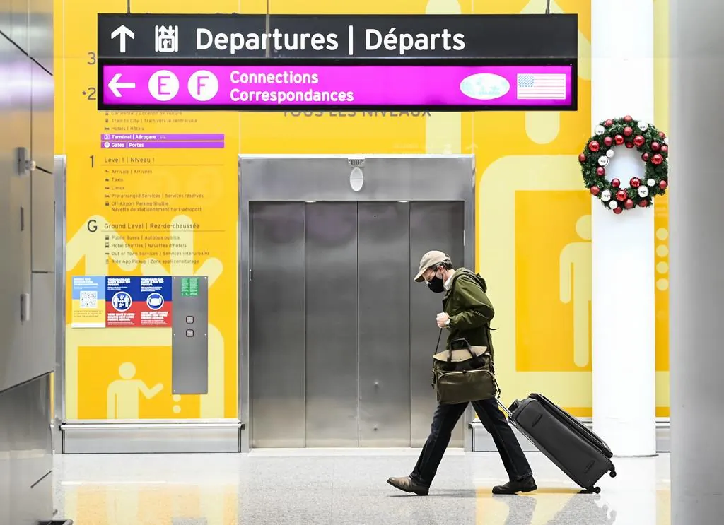 A man makes his way through Pearson International Airport during the COVID-19 pandemic in Toronto on Dec. 14, 2020. (Nathan Denette/The Canadian Press)
