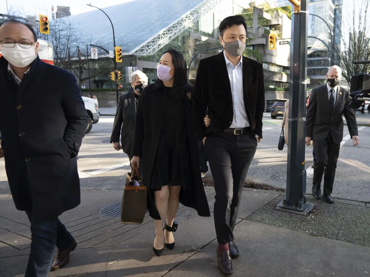Huawei CFO Meng Wanzhou leaves the B.C. Supreme Court with her husband, Liu Xiaozong, during a break from an extradition hearing in Vancouver Jan. 13, 2021. (The Canadian Press/Jonathan Hayward)