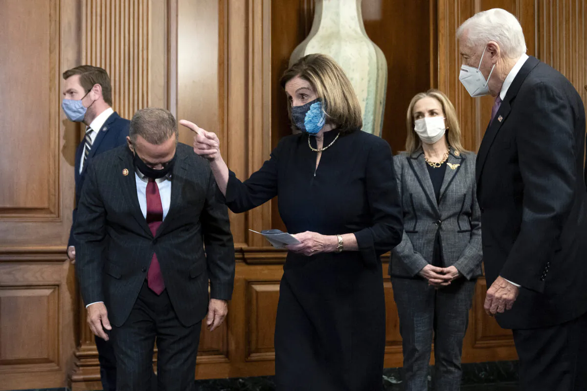 Speaker of the House Nancy Pelosi (D-Calif.) (C) arrives to sign an article of impeachment against President Donald Trump at the Capitol in Washington on Jan. 13, 2021. (Stefani Reynolds/Getty Images)