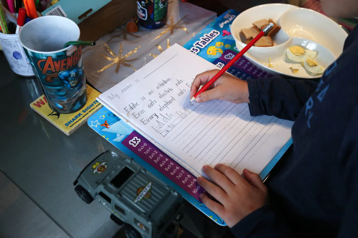 Donna Eddy helps her son Phoenix with school work at their home in Sydney, Australia on April 9, 2020. (Brendon Thorne/Getty Images)