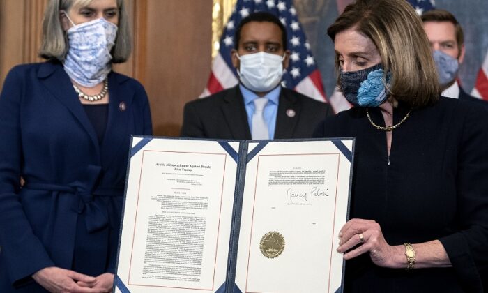 Speaker of the House Nancy Pelosi (D-Calif.) displays a signed article of impeachment against President Donald Trump at the U.S. Capitol on Jan. 13, 2021. (Stefani Reynolds/Getty Images)