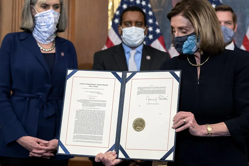 Speaker of the House Nancy Pelosi (D-Calif.) displays a signed article of impeachment against President Donald Trump at the U.S. Capitol on Jan. 13, 2021. (Stefani Reynolds/Getty Images)