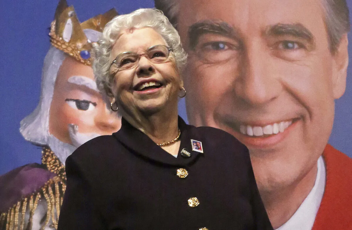 Joanne Rogers stands in front of a giant Mister Rogers Forever Stamp in Pittsburgh on March 23, 2018. (AP Photo/Gene J. Puskar)