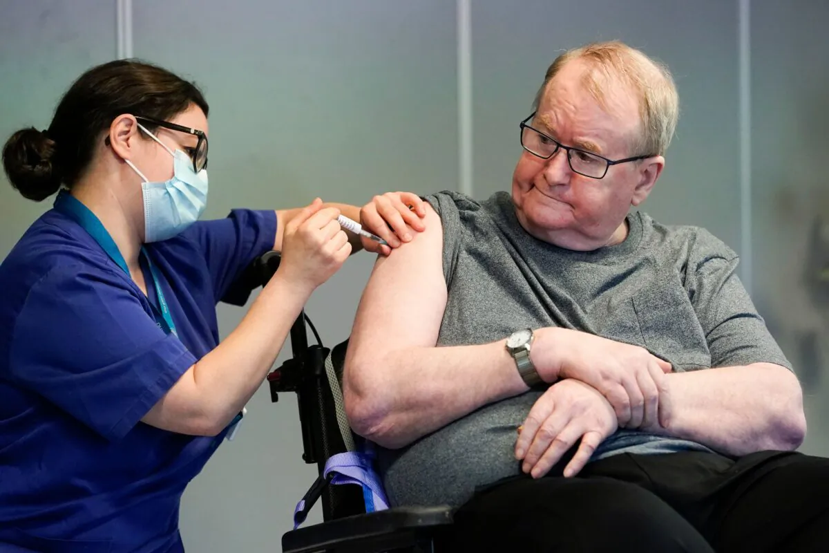 Svein Andersen, 67-year-old resident of 'Ellingsrud home' and first in Norway to receive the vaccine, is given the Pfizer-BioNTech CCP vaccine by nurse Maria Golding in Oslo, Norway, on Dec. 27, 2020. (Fredrik Hagen/NTB/AFP via Getty Images)