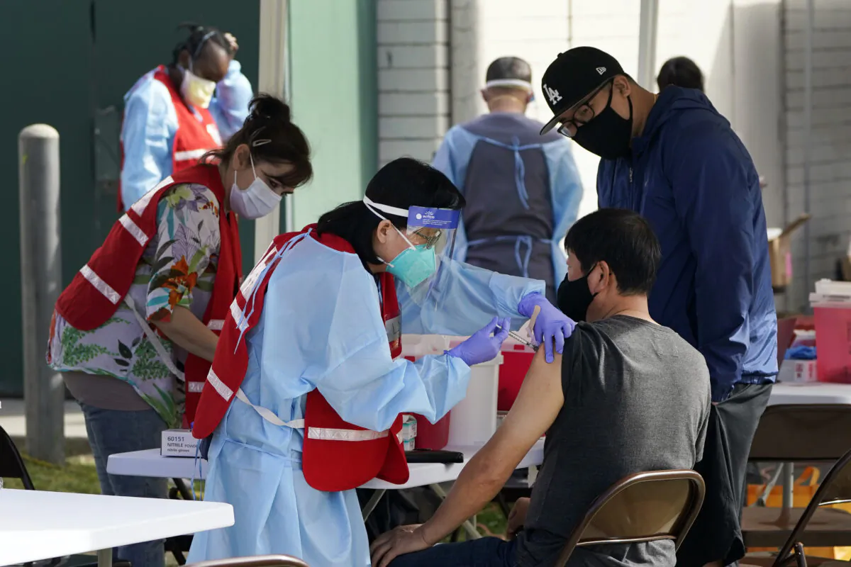 Health care workers receive a COVID-19 vaccination at Ritchie Valens Recreation Center in Pacoima, Calif., on Jan. 13, 2021. (Marcio Jose Sanchez/AP Photo)