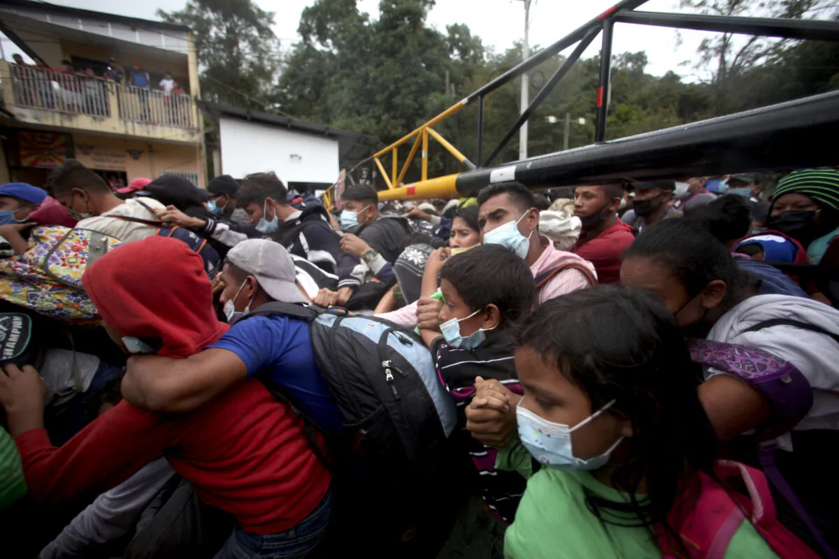 Honduran migrants hoping to reach the U.S. cross the border patrolled by Guatemalan soldiers, in El Florido, Guatemala, on Jan. 16, 2021. (Sandra Sebastian/AP Photo)