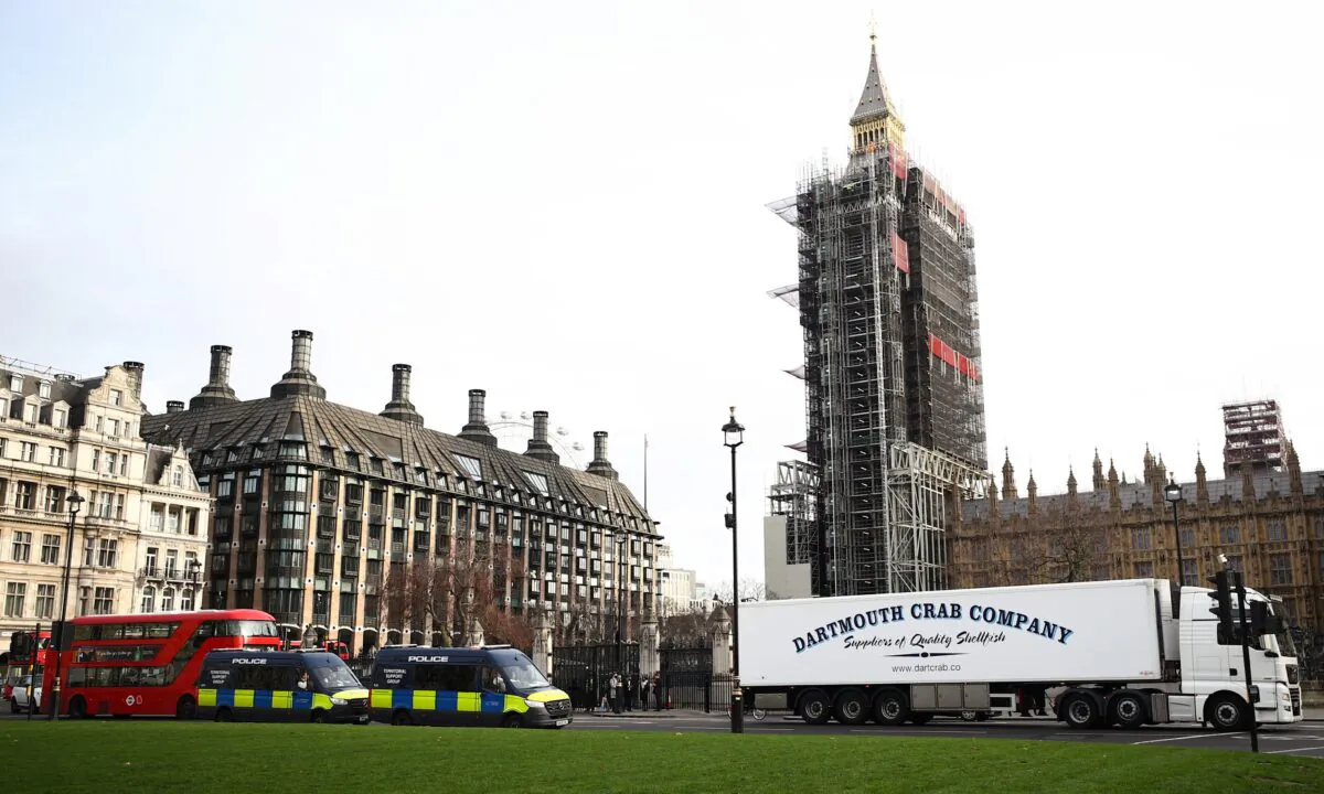 A lorry drives during a protest against post-Brexit bureaucracy that hinders exports to the European Union, as police officers in vans watch over the demonstration at the Parliament Square in London, on Jan. 18, 2021. (Hannah McKay/Reuters)