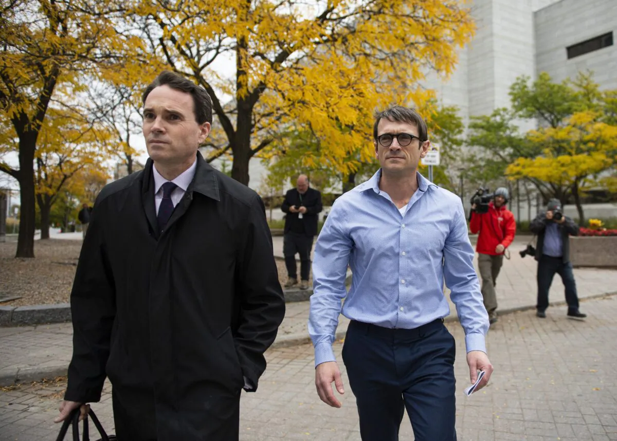 Cameron Ortis (R), a former senior intelligence official with the RCMP charged with violating the Security of Information Act and breach of trust, leaves the courthouse in Ottawa with his lawyer after being granted bail on Oct. 22, 2019. (The Canadian Press/Justin Tang)