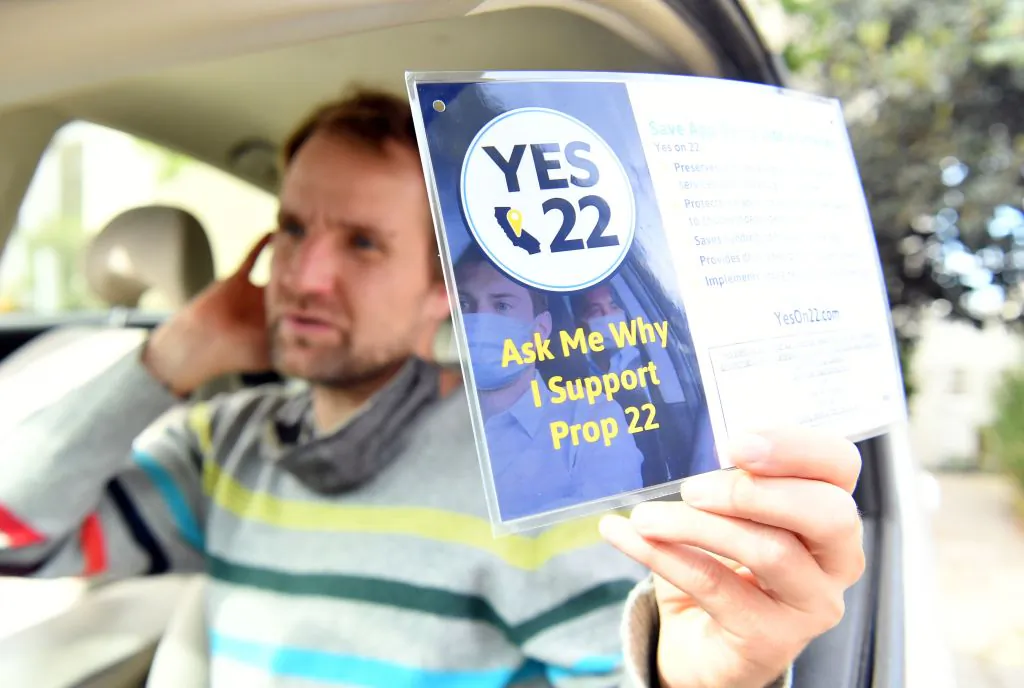 Uber driver Sergei Fyodorov shows his support for Proposition 22, a ballot measure that passed and allowed ride-share drivers to work as independent contractors, in Oakland, Calif., on Oct. 9, 2020. (Josh Edelson/AFP via Getty Images)