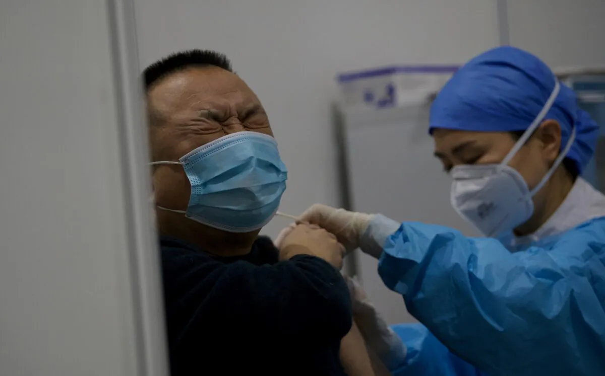 A medical worker inoculates a man with a COVID-19 vaccine at the Chaoyang Museum of Urban Planning in Beijing, on Jan. 15, 2021. (Noel Celis/AFP via Getty Images)