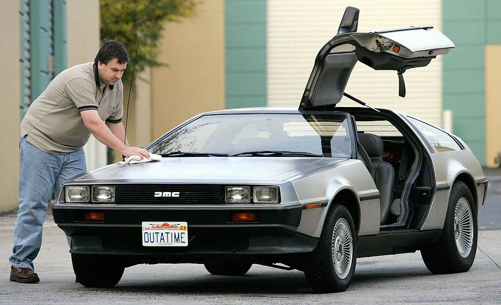 Wayne Gillard polishes up his 1981 DeLorean DMC 12, one of only six in Australia and up for auction at a novelty auction, seen in this 15 July 2004 file photo in Melbourne. (WILLIAM WEST/AFP via Getty Images)