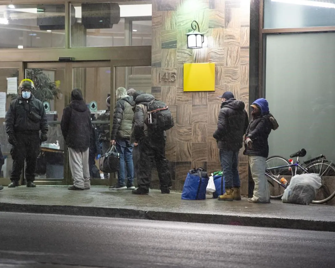 People lineup at a hotel for the homeless before the 8 p.m. COVID-19 curfew on Jan. 11, 2021, in Montreal. (Ryan Remiorz/The Canadian Press)