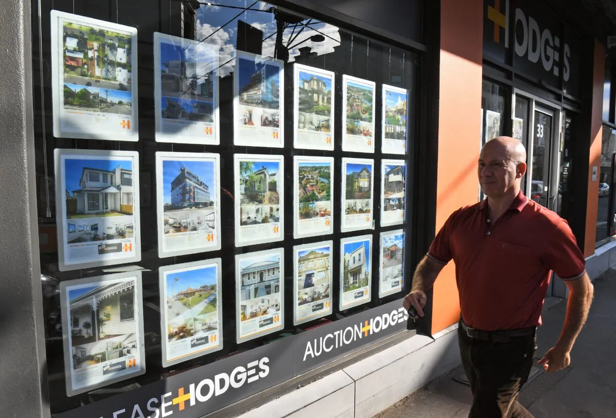 A man walks past a real estate agent's window advertisements in Melbourne on May 1, 2019. (Photo by WILLIAM WEST/AFP via Getty Images)