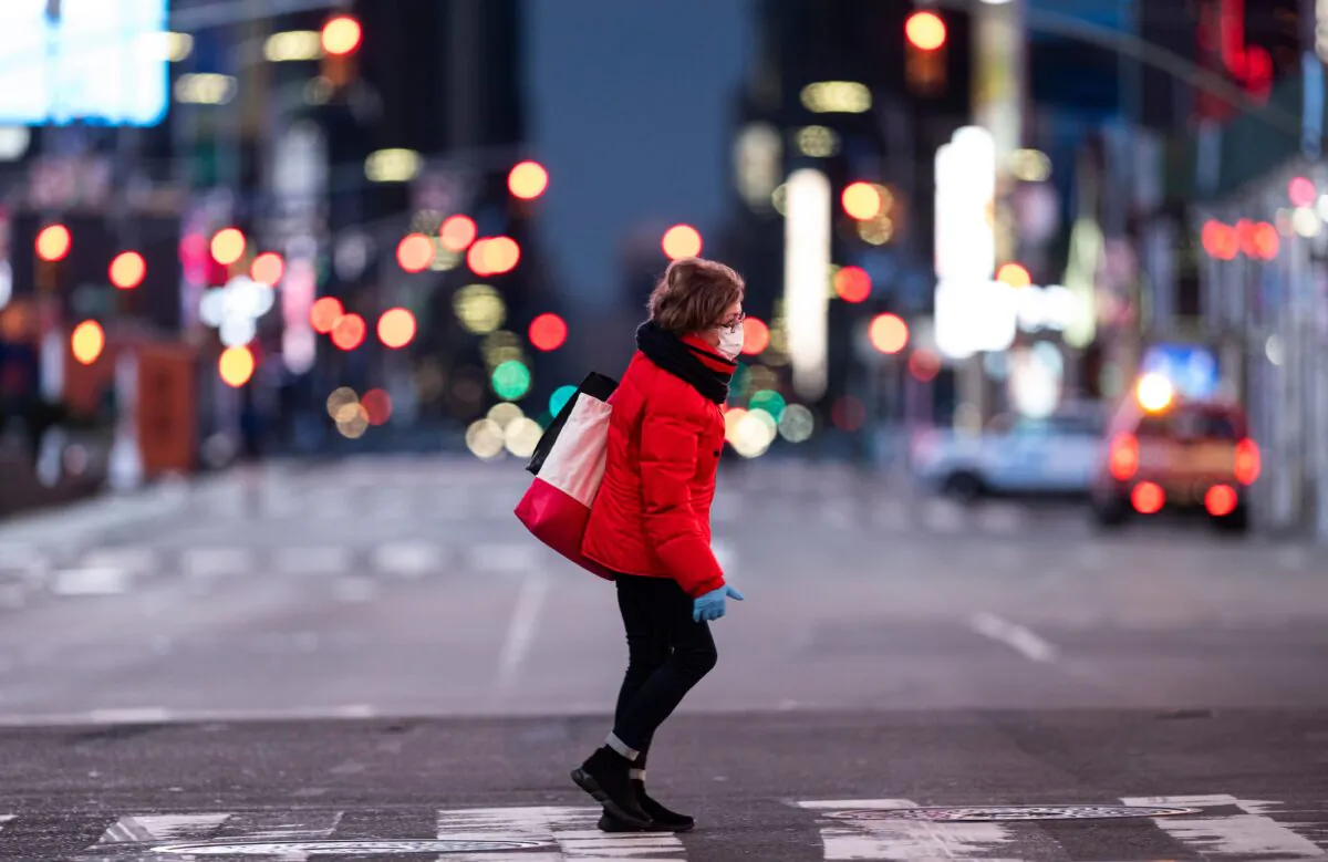 A woman walks through an almost-deserted Times Square in the early morning hours in New York City on April 23, 2020. (Johannes Eisele/AFP via Getty Images)