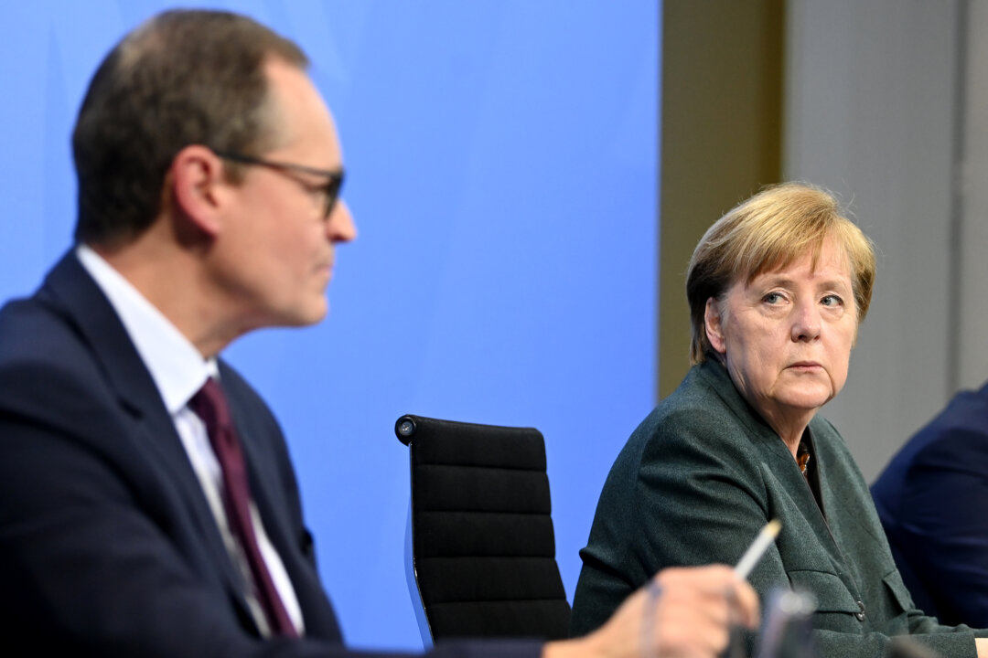 German Chancellor Angela Merkel listens to Berlin's Mayor Michael Mueller during a press conference following a video conference with the Prime Ministers of the federal states discussing new measures to bring down the numbers of COVID-19 infections, in Berlin on Jan. 19, 2021. (Filip Singer-Pool/Getty Images)