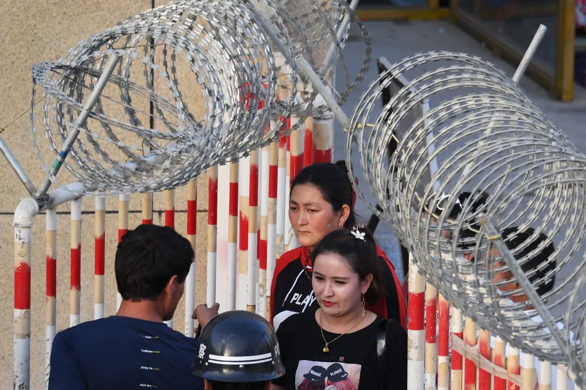 A Uyghur woman (C) goes through an entrance to a bazaar in Hotan, in China's northwest Xinjiang region, on May 31, 2019. (Greg Baker/AFP via Getty Images)