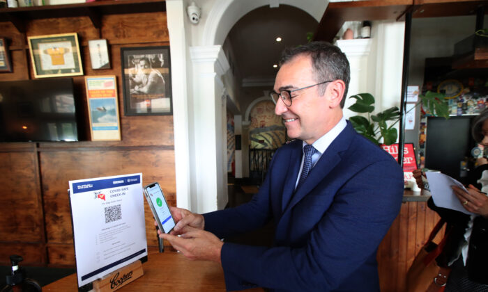 South Australian Premier Steven Marshall demonstrates checking in via QR code to help with contact tracing at the Stag Hotel on December 01, 2020 in Adelaide, Australia. (Kelly Barnes/Getty Images)