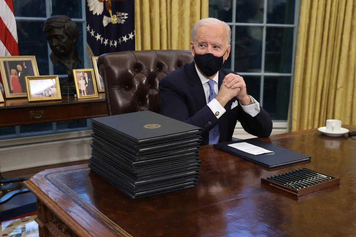 President Joe Biden prepares to sign a series of executive orders at the Resolute Desk in the Oval Office hours after his inauguration in Washington on Jan. 20, 2021. (Chip Somodevilla/Getty Images)