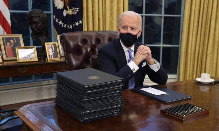 President Joe Biden prepares to sign a series of executive orders at the Resolute Desk in the Oval Office hours after his inauguration in Washington on Jan. 20, 2021. (Chip Somodevilla/Getty Images)